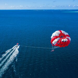 a person is parasailing over the ocean with a boat