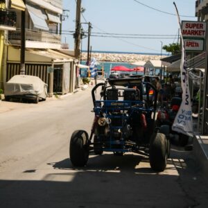 A buggy driving down a street next to tall buildings