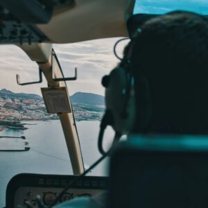a man flying a helicopter over a large body of water