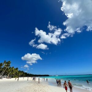 A group of people walking along a beach next to the ocean