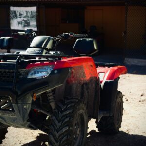 a red four wheeler parked in front of a building